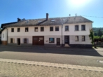 Straßenansicht - Geräumiges Zweifamilienhaus mit Gewerbe, vielen Stellplätzen und idyllischem Garten in Friedelhausen